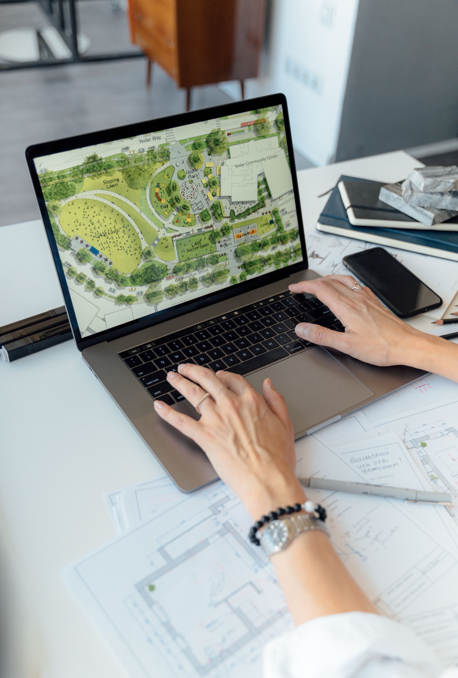 Planung und Organisation am Laptop, Bauunterlagen auf dem Tisch